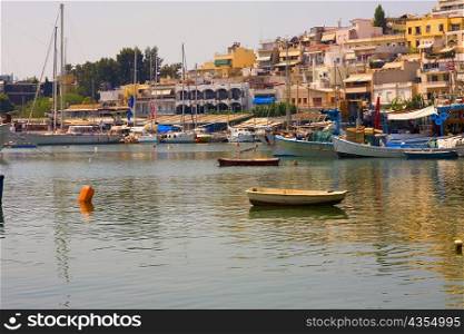Boats in water with buildings in the background, Athens, Greece