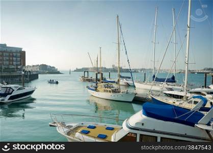 Boats moored at Gunwharf Quays marina at the entrance to the historic British Naval base of Portsmouth, UK