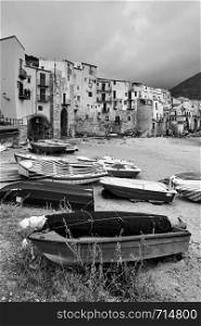 Boats on the beach and old houses by the sea in Cefalu, Sicily, Italy - Black and white landscape
