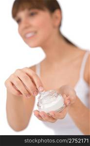 Body care - Female teenager applying moisturizer cream on face, focus on cream