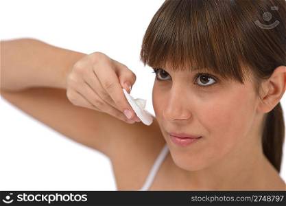 Body care - Female teenager cleaning face with cotton pad, removing make-up