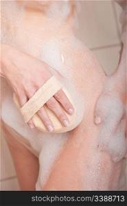 Body care: Woman in shower with washcloth and foam in the bathroom