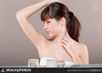 Body care: Young woman in bathroom, on gray background