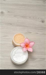 Body lotion and bath salt displayed with a frangipani flower