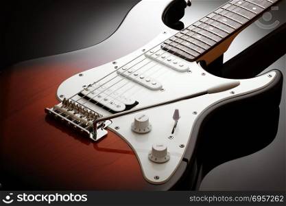 Body of the electric guitar. Close up on the body of elegant electric guitar with sunburst finish, black glossy background