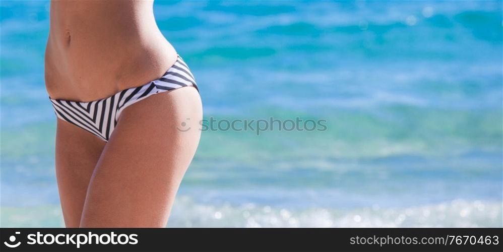 Body part of slim and sporty young girl over sea background, traveling and vacation concept. Slim and sporty girl over sea