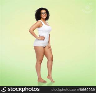 body positive and people concept - happy african american woman in white underwear over lime green natural background. happy african american woman in white underwear. happy african american woman in white underwear