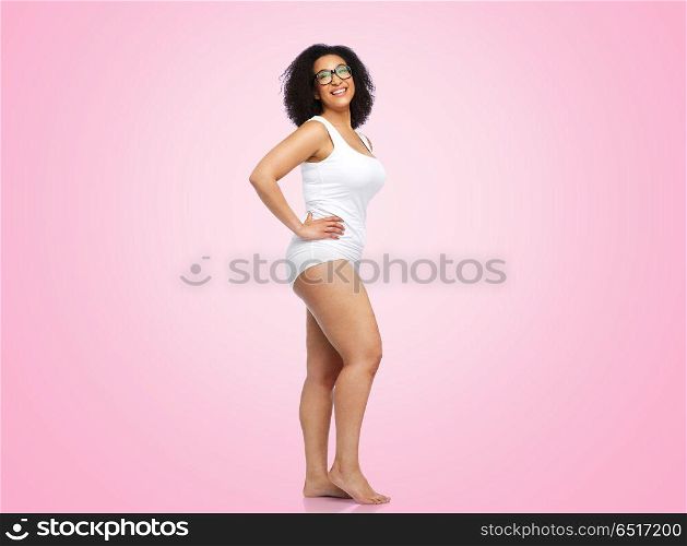 body positive and people concept - happy african american woman in white underwear over pink background. happy african american woman in white underwear. happy african american woman in white underwear