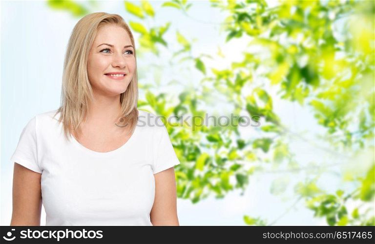 body positive and people concept - happy woman in white t-shirt over green natural background. happy woman in white t-shirt. happy woman in white t-shirt