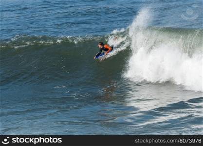 Bodyboarder in action on the ocean waves on a sunny day.