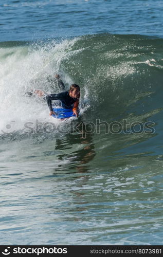 Bodyboarder in action on the ocean waves on a sunny day.