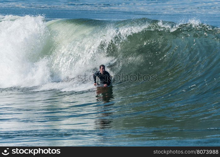 Bodyboarder in action on the ocean waves on a sunny day.