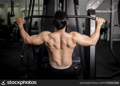 Bodybuilder man with big muscular back in the gym