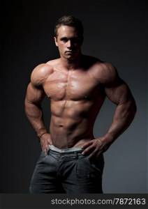 bodybuilder posing. Handsome power athletic guy male. Fitness muscular body on black background.