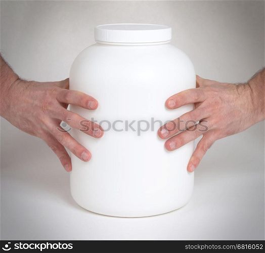 Bodybuilding and Sports themehands holding a plastic jar with a dry protein, isolated on white