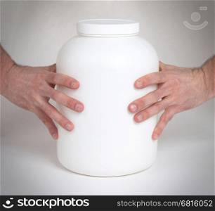 Bodybuilding and Sports themehands holding a plastic jar with a dry protein, isolated on white