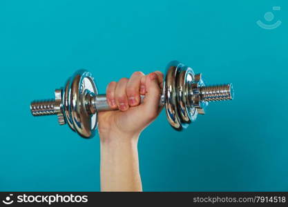 Bodybuilding. fit man exercising with dumbbells. Closeup young guy lifting weights on blue