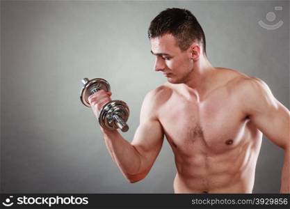 Bodybuilding. Strong fit man exercising with dumbbells. Closeup muscular young guy lifting weights dark background