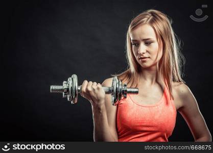 Bodybuilding. Strong fit woman exercising with dumbbells. Muscular blonde girl lifting weights studio shot on black background