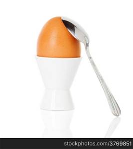 boiled Brown egg in cup, on a stand with a spoon isolated on white