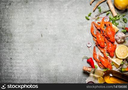 Boiled crawfish with a bottle of white wine and slices of lemon. On a stone background.. Boiled crawfish with a bottle of white wine