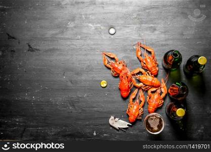 Boiled crawfish with beer. On a black chalkboard.. Boiled crawfish with beer.