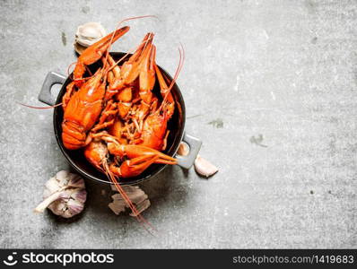 Boiled crawfish with garlic. On a stone background.. Boiled crawfish with garlic.