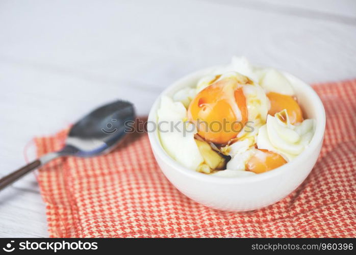 boiled egg on bowl with sauce for breakfast on the table background / Soft boiled eggs