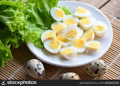 boiled eggs food, quail eggs on white plate, breakfast eggs with fresh quail eggs and vegetable coriander on wooden table background