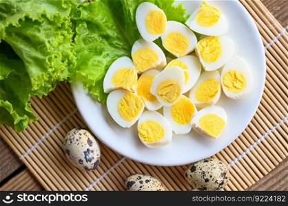 boiled eggs food, quail eggs on white plate, breakfast eggs with fresh quail eggs and vegetable lettuce on table background - top view