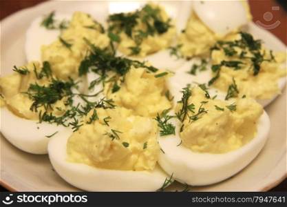 Boiled eggs sliced in halves stuffed and filling by pasta with dill