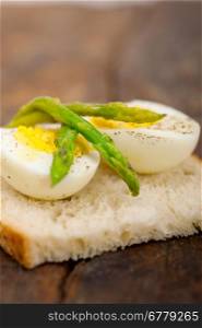 boiled fresh green asparagus and eggs with extra virgin olive oil with rustic bread