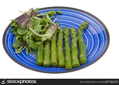 boiled green asparagus with salad mix on blue plate