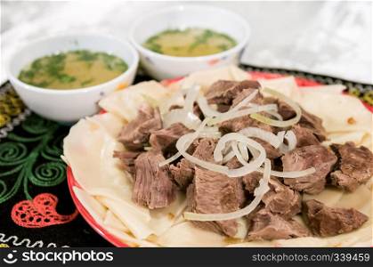 boiled meat on a plate with onion and dough