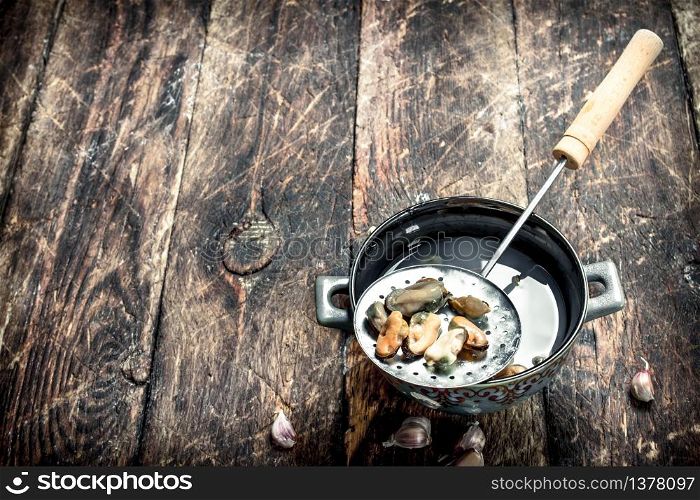 Boiled mussels in a bowl. On a wooden background.. Boiled mussels in a bowl.