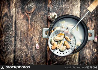 Boiled mussels in a bowl. On a wooden background.. Boiled mussels in a bowl.