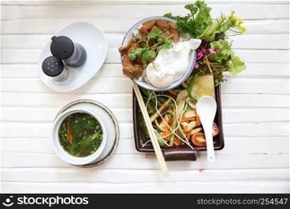 boiled pork roast with rice and egg on wood background