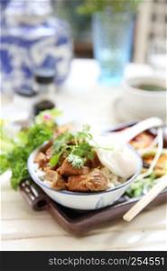 boiled pork roast with rice and egg on wood background