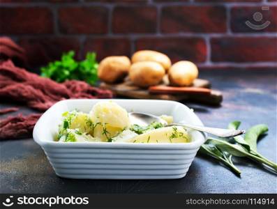 boiled potato in white bowl and on a table