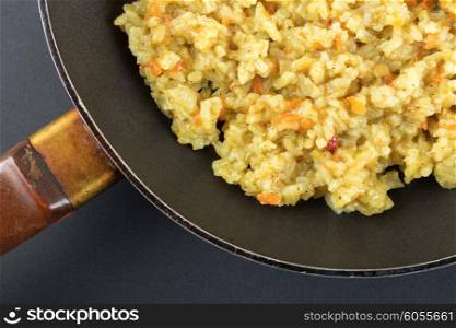 Boiled rice in a frying pan on a black background