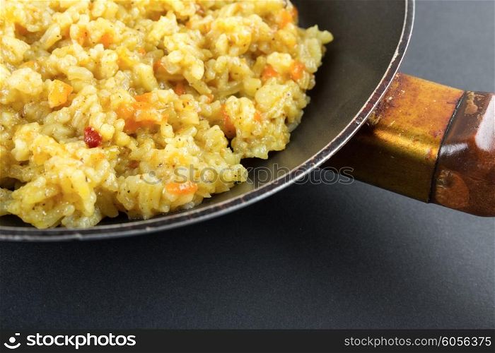 Boiled rice in a Teflon frying pan on a black background