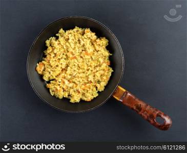 Boiled rice in a Teflon frying pan on a black background