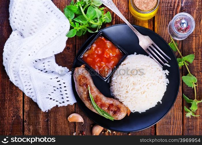 boiled rice with fried sausages on the plate