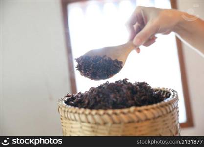 Boiled riceberry rice on Wicker basket with spoon in close up