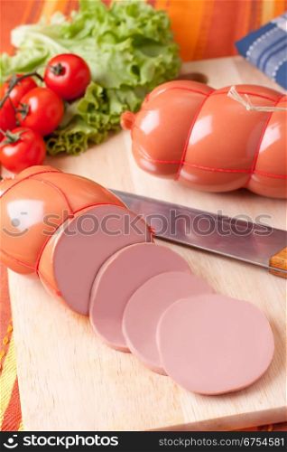 boiled sausage, on a wooden cutting board.