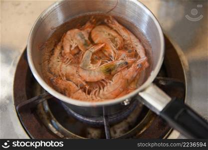 Boiled shrimps in a hot pot on the stove, shrimp prawn cooking menu food concept