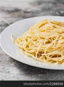 Boiled spaghetti on a plate. On a gray background. High quality photo. Boiled spaghetti on a plate.