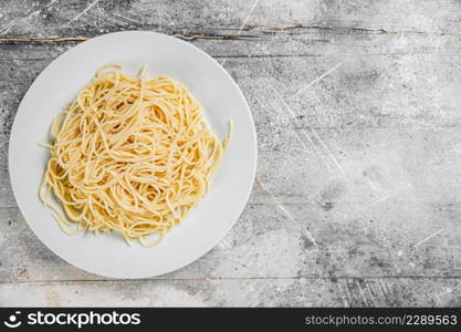 Boiled spaghetti on a plate. On a gray background. High quality photo. Boiled spaghetti on a plate.