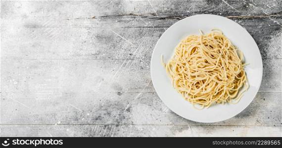Boiled spaghetti on a plate. On a gray background. High quality photo. Boiled spaghetti on a plate.