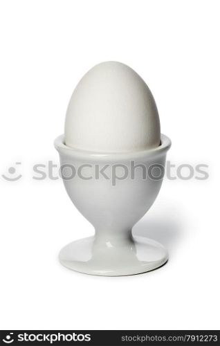 Boiled white egg in an eggcup on white background